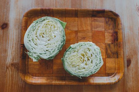 fresh cabbage top view on a wooden table. juicy white cabbage salad on a white plate. copy spaceの写真素材