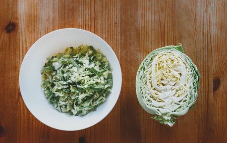 fresh cabbage top view on a wooden table. juicy white cabbage salad on a white plate. copy spaceの写真素材