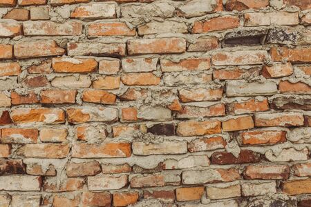 old brick wall, crooked brown bricks, uneven seams, brickwork collapsedの写真素材