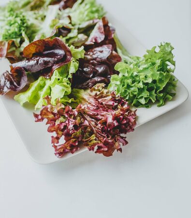 a juicy plate with fresh mixed salads stands on a white background. dietary healthy foodの写真素材