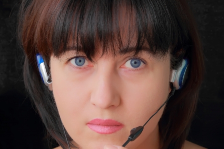 Portrait of young woman in earphone with blue eyesの写真素材