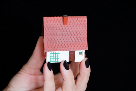 Image of dollhouse in human hand on black backgroundの写真素材