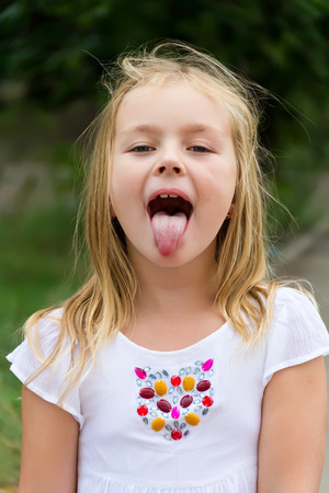 Portrait of cute girl with put out tongueの写真素材