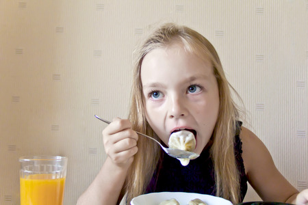 Photo of eating cute girl with blond hairの写真素材