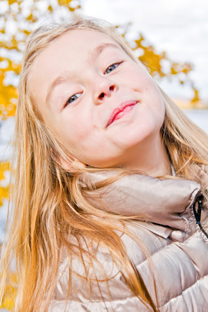 Photo of cute smiling girl in autumnの写真素材