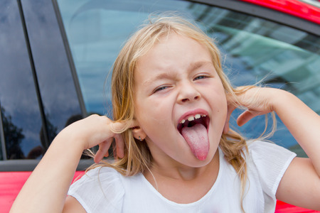 Portrait of cute girl with put out tongueの写真素材