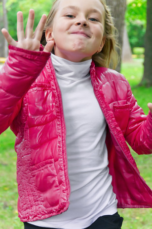 Cute jumping girl with blond hair in summerの写真素材