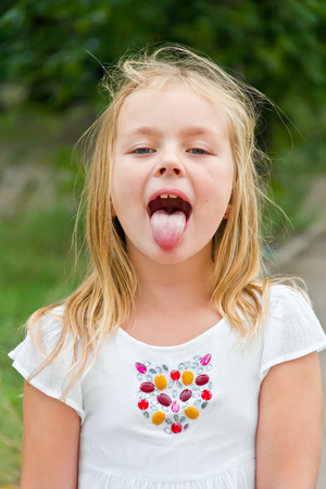 Portrait of cute girl with put out tongueの写真素材