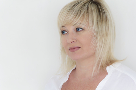 European blond woman with blue eyes in whiteの写真素材