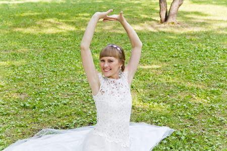 Beautiful bride in white lace dress with upwards handsの写真素材
