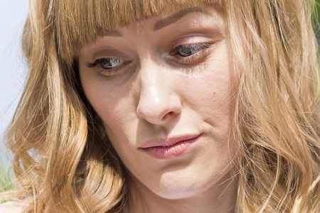 Horizontal portrait of young thinking woman with big blue eyesの写真素材