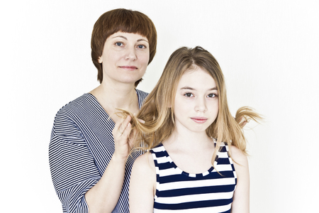 Happiest mother and daughter near white wall in striped clothesの写真素材