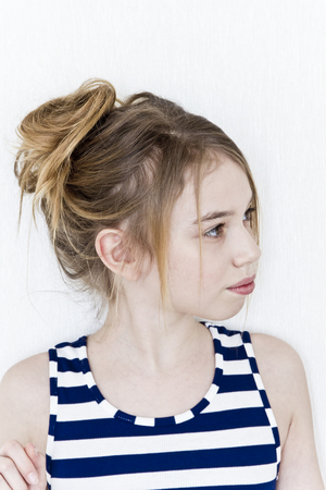 Cute girl eleven years old with blond long hair on white backgroundの写真素材