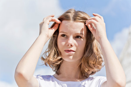 Portrait of cute blond girl are straightening hair