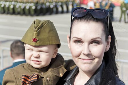 Samara, Russia - May 9, 2017: Mother with baby in soldier costume at the honor of annual Victory Dayのeditorial素材