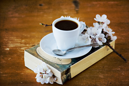cup of coffee, a book and blossoming branchの写真素材