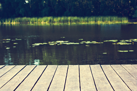 Pier, river and forest. Beautiful summer green view. Summer background. Rest on the forest lake. View from the shore of the fishing lake in the early morning. Place for text.の写真素材