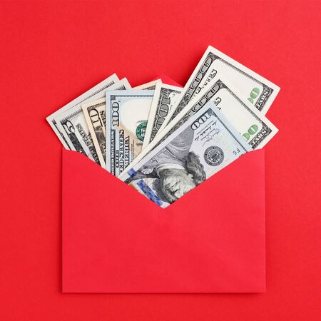Fan US dollars in cash in red envelope on red background. Money gift, finance concept. Top view, minimal, square.の写真素材