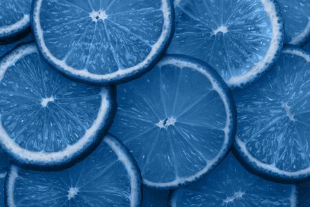 Close-up citrus slices abstract background in Classic blue color of the year 2020. Bright trendy texture.の写真素材