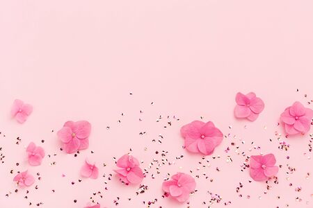 Pink flowers and Gold glitter confetti frame on copy space background. Spring, summer Holidays. Birthday, Mothers Day. Flat lay.の写真素材