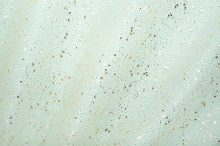 Airy fabric waves with gold glitter on light blue background. Abstract, chic holiday flat lay.