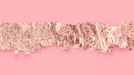 Rose gold paper strip torn on pink background, copy space, art design.の写真素材