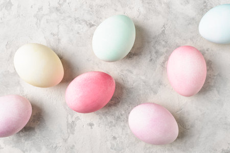 Pastel dyed Easter eggs diagonal on light grey background, flat lay.の写真素材