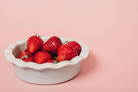 Fresh ripe delicious strawberries in a  bowl on a white background. Summer concept. の写真素材