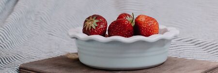 Strawberries in a plate on the wooden board. Summer concept.の写真素材