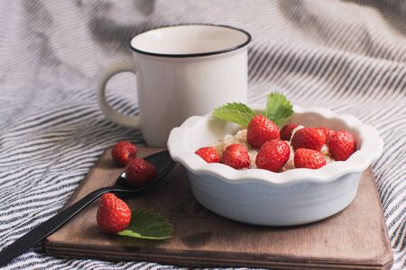 Breakfast. Tasty oatmeal with berries. Healthy breakfast ingredients. Oat granola in bowl with strawberry and mint. Granola for breakfast with berries.の写真素材