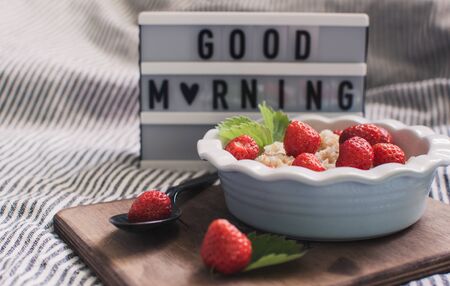 Breakfast. Tasty oatmeal with berries. Healthy breakfast ingredients. Oat granola in bowl with strawberry and mint. Granola for breakfast with berries.の写真素材