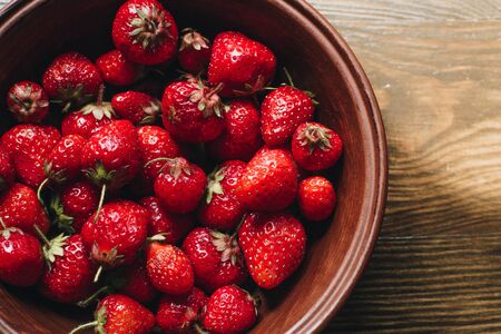 Strawberries in a plate on the wooden board. Summer concept.の写真素材