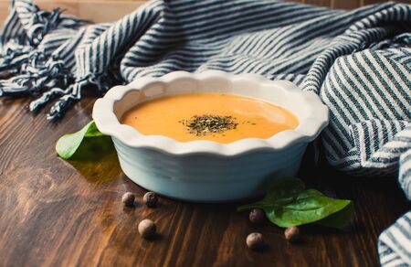 Pumpkin and carrot cream soup on the dark wooden table. Healthy food.の写真素材