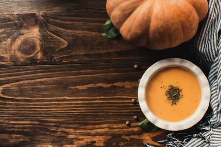 Pumpkin and carrot cream soup on dark wooden background. Pumpkin. Thanksgiving concept.の写真素材