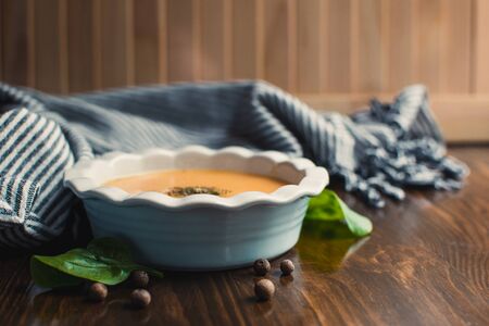 Pumpkin and carrot cream soup on the dark wooden table. Healthy food.の写真素材