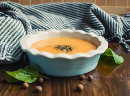 Pumpkin and carrot cream soup on the dark wooden table. Healthy food.の写真素材