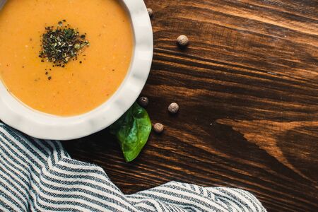 Pumpkin and carrot cream soup on the dark wooden table. Healthy food.の写真素材