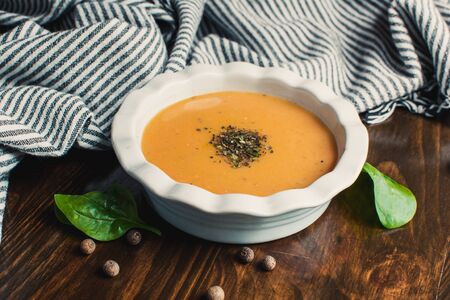 Pumpkin and carrot cream soup on the dark wooden table. Healthy food.の写真素材