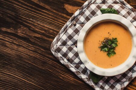 Pumpkin and carrot cream soup on the dark wooden table. Healthy food.の写真素材