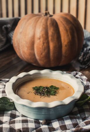 Pumpkin and carrot cream soup on dark wooden background. Pumpkin. Thanksgiving concept.の写真素材