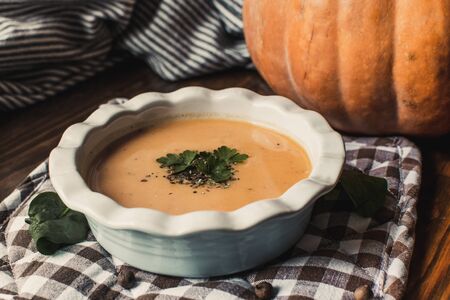 Pumpkin and carrot cream soup on dark wooden background. Pumpkin. Thanksgiving concept.の写真素材