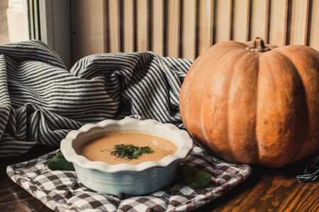 Pumpkin and carrot cream soup on dark wooden background. Pumpkin. Thanksgiving concept.の写真素材