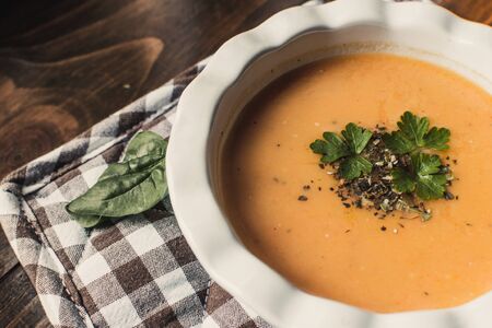 Pumpkin and carrot cream soup on the dark wooden table. Healthy food.の写真素材
