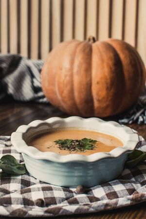 Pumpkin and carrot cream soup on dark wooden background. Pumpkin. Thanksgiving concept.の写真素材