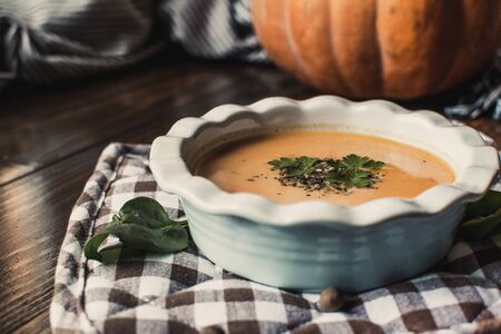 Pumpkin and carrot cream soup on dark wooden background. Pumpkin. Thanksgiving concept.の写真素材