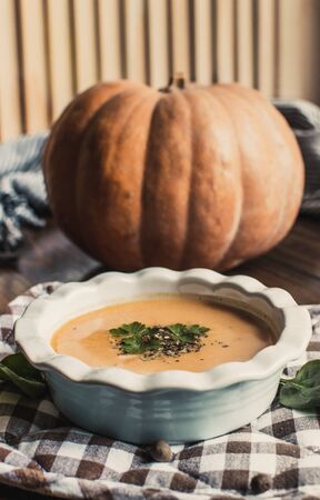 Pumpkin and carrot cream soup on dark wooden background. Pumpkin. Thanksgiving concept.の写真素材