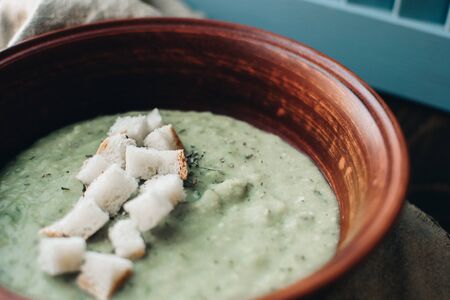 Green cream vegetable soup broccoli, peas, zucchini, spinach with croutons. Delicious vegetarian healthy food.の写真素材