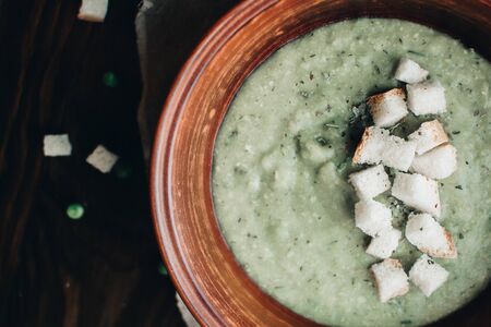 Green cream vegetable soup broccoli, peas, zucchini, spinach with croutons. Delicious vegetarian healthy food.の写真素材