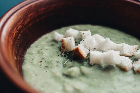 Green cream vegetable soup broccoli, peas, zucchini, spinach with croutons. Delicious vegetarian healthy food.の写真素材