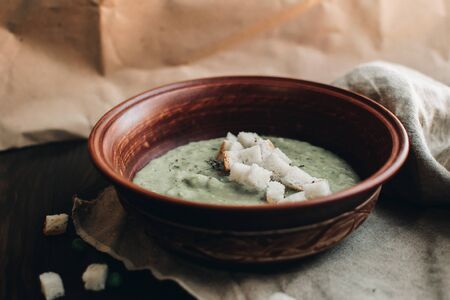 Green cream vegetable soup broccoli, peas, zucchini, spinach with croutons. Delicious vegetarian healthy food.の写真素材